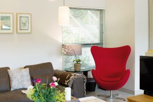 Červené čtenářské křeslo je výrazným solitérem a spolu s dalšími červenými prvky dodává interiéru šťávu. FOTO UNIQUE HOME STAYS UK