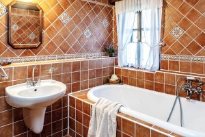 V koupelně je použit rustikální obklad a dlažba. Některé obkladačky jsou ručně malované. FOTO JIŘÍ HURT