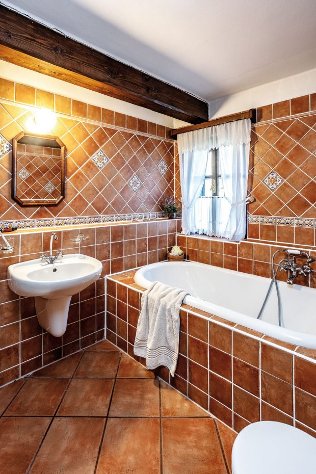 V koupelně je použit rustikální obklad a dlažba. Některé obkladačky jsou ručně malované. FOTO JIŘÍ HURT