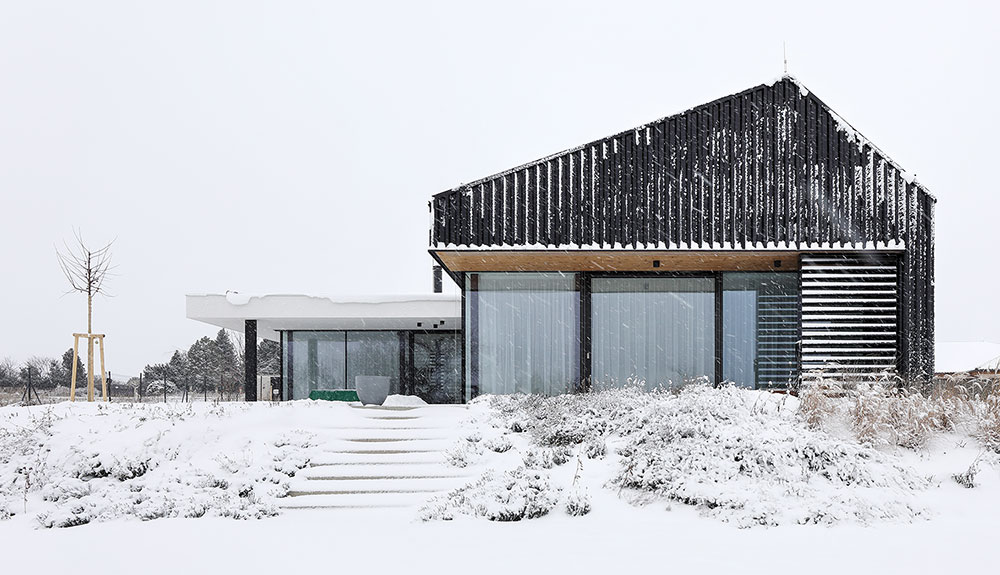 Inteligentní moderní dům se sjednocenou fasádou a střechou v zime