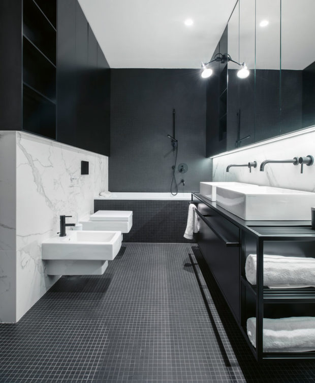 V koupelně taktéž dominuje kontrast černé a bílé barvy, kterou opticky zjemňuje použití mramoru.