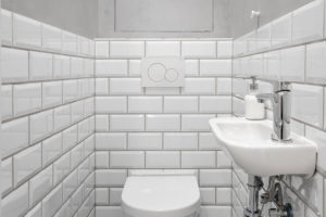 Koupelna ma geometrickým obkladem připomínajícím bílé cihly