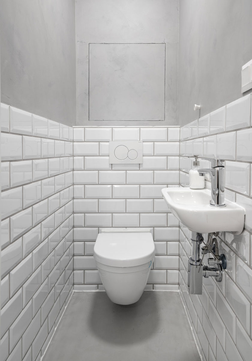 Koupelna ma geometrickým obkladem připomínajícím bílé cihly