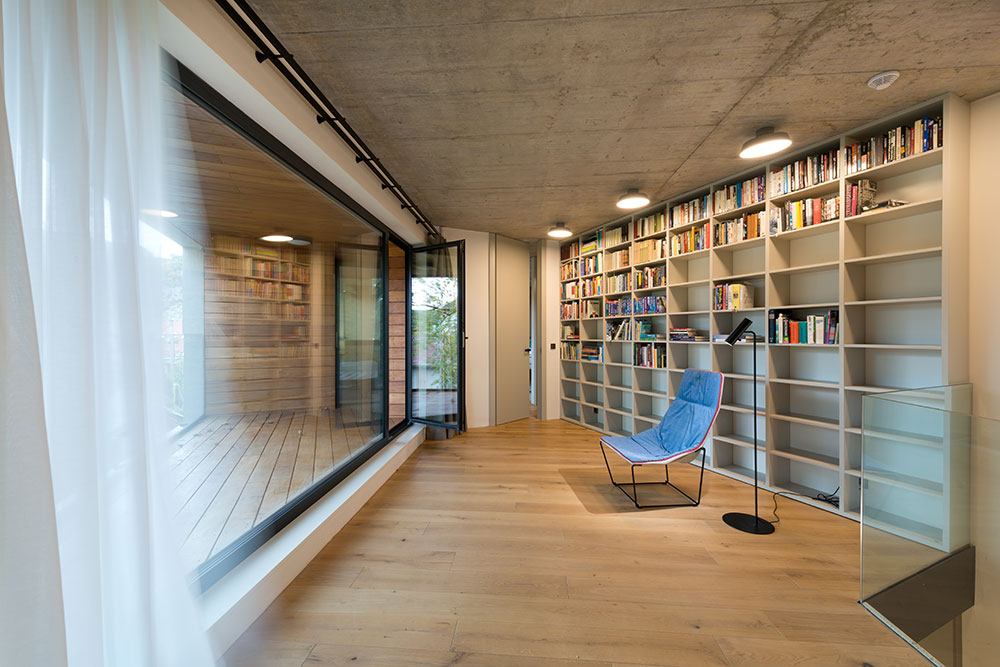 Interiérový minimalismus z nábytku na míru v barvě bílé kávy, šedých pohledových betonů a dubových podlah.