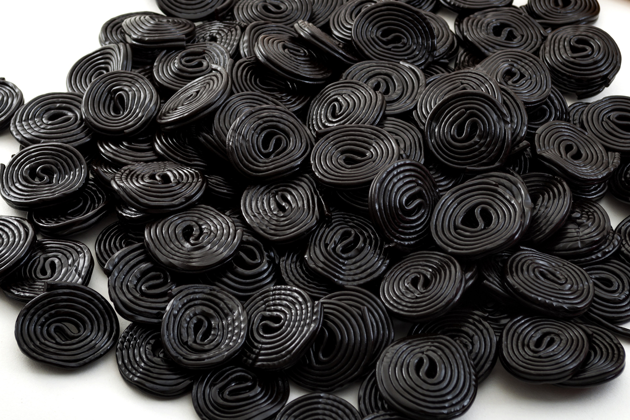 Heap of black licorice wheels isolated on white background