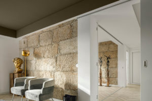 obývacia izba s kreslami v byte s kamennou stenou