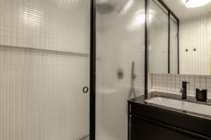 Sprchový kout za drátovaným sklem v černých rámech