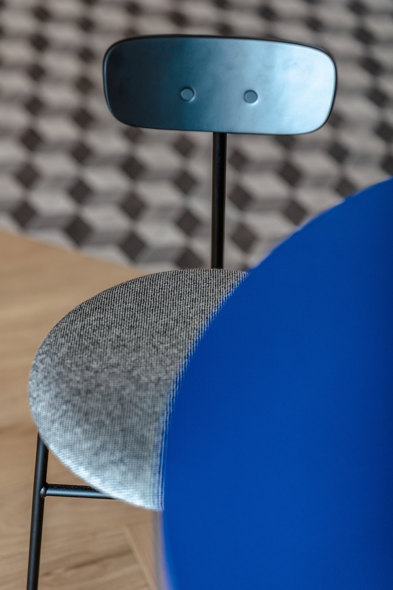 Modrý jídelní stůl oválného tvaru šedá židle