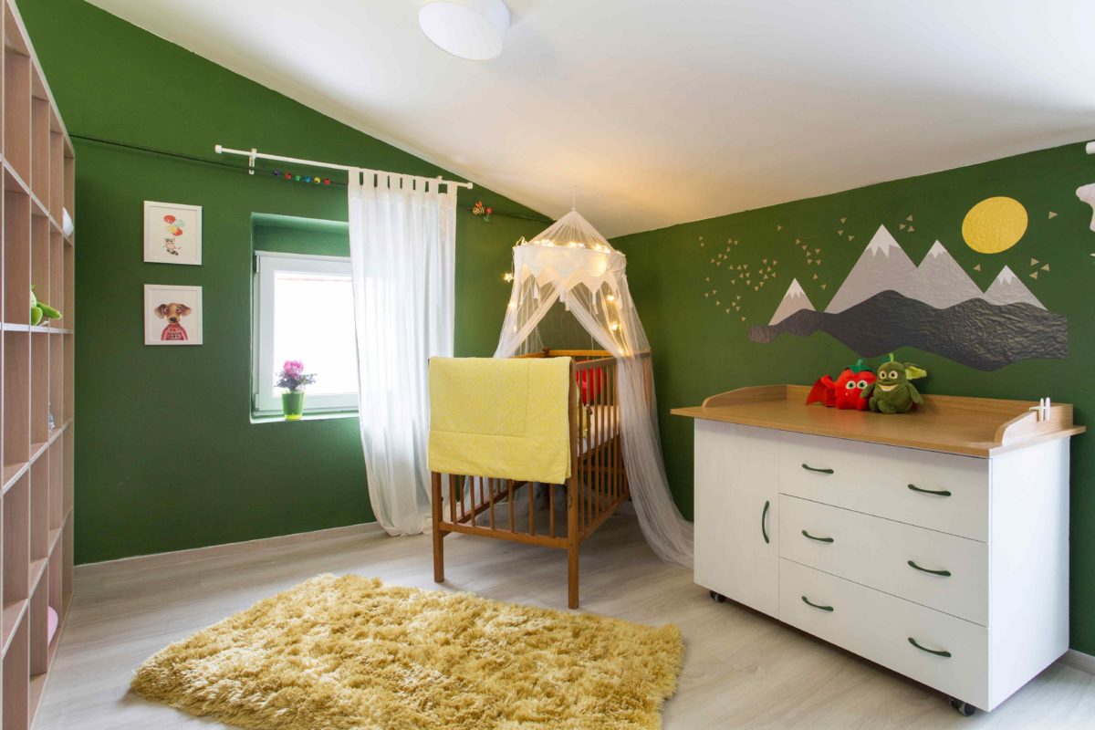 Dětský pokoj se zelenou stěnou a postýlkou