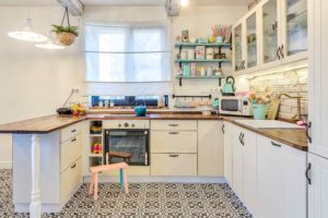 Kuchyň s bílou linkou a mozaikovou dlažbou