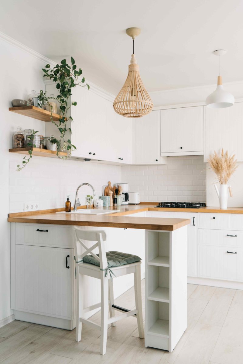 Bílá kuchyň s dřevěnou pracovní doskou