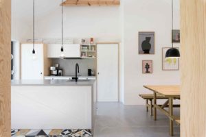Kuchyň s bílou linkou a dřevěnou lavicí