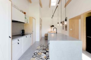 Kuchyň s bílou linkou a dřevěnou lavicí