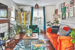 Barevný obývák s oranžovým gaučem a květinami