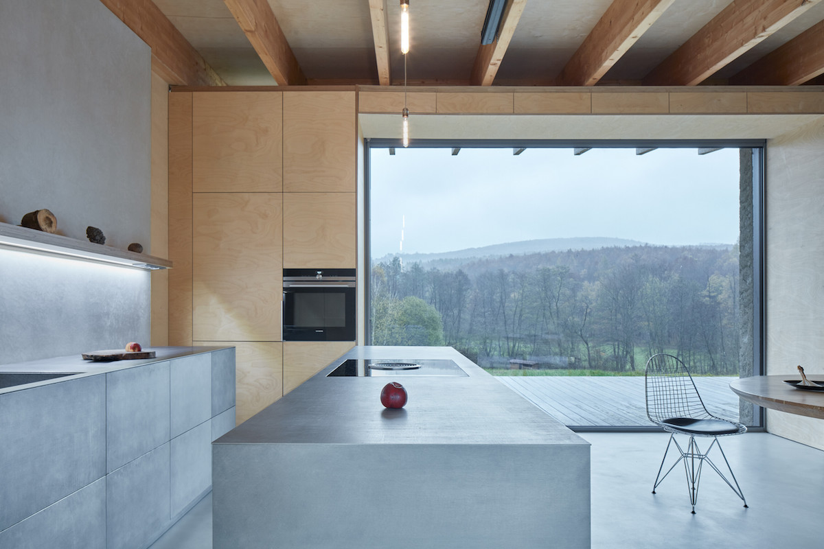 Sivá kuchyň s ostrůvkem a velkým oknem