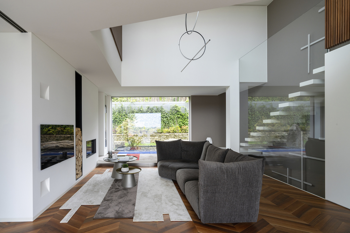 Moderní obývací pokoj s prosklenou stěnou a krbem