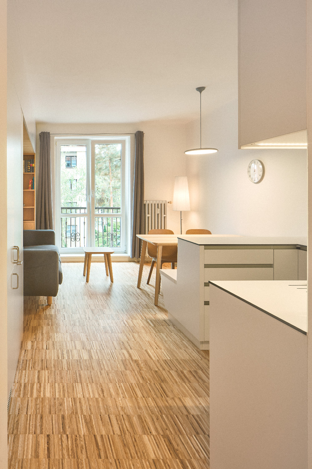 Kuchyň s dřevěnou podlahou a bílou linkou