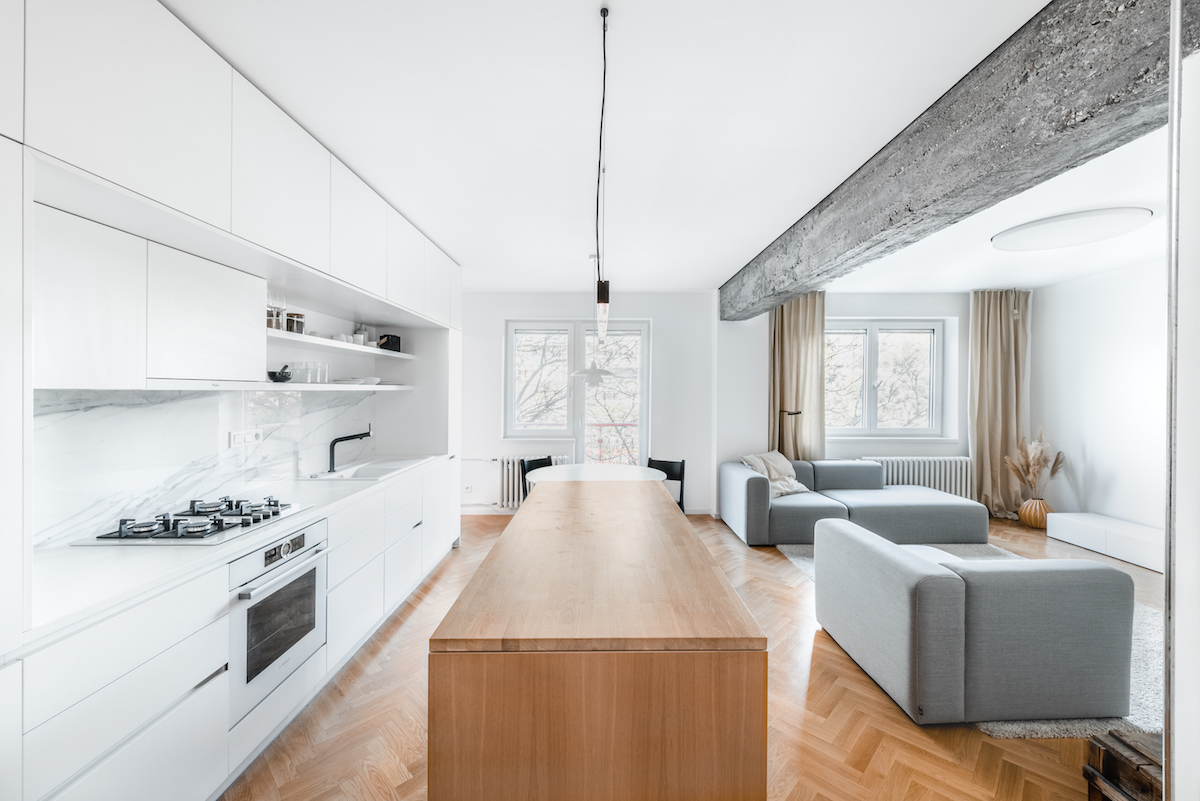 Svetlý obývák spojený s kuchyní s betonovým pilířem