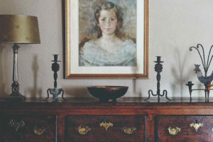 Portrét ženy a svícny na starožitném stolku