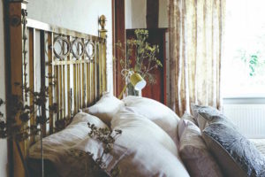 Mosazná postel s polštářy