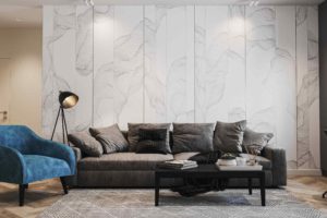 Obývací pokoj s velko šedou pohovkou a tyrkysovým křeslem