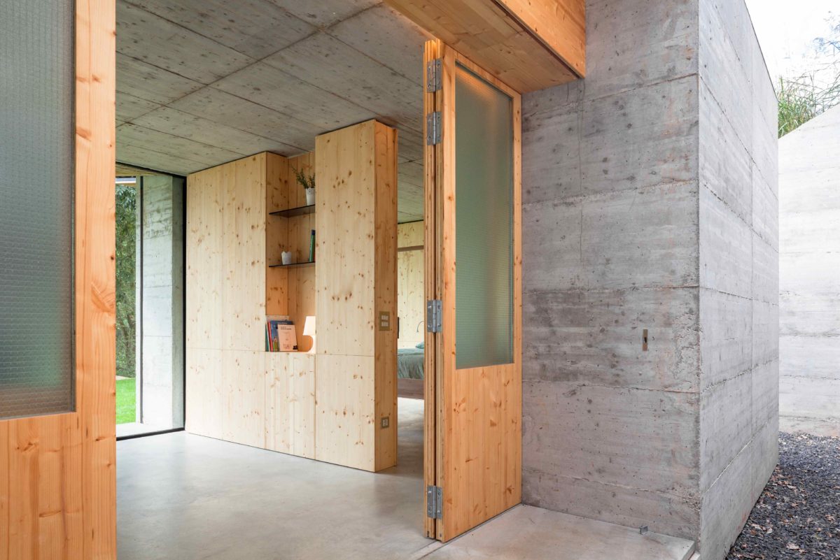 Drevěný nábytek v betonovém domě s otevřeným vchodem