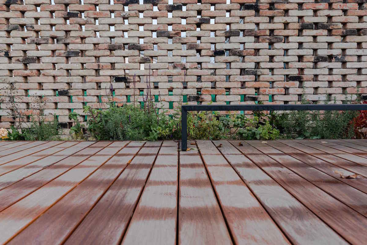 Detail dřevěné terasy a cihlového plotu
