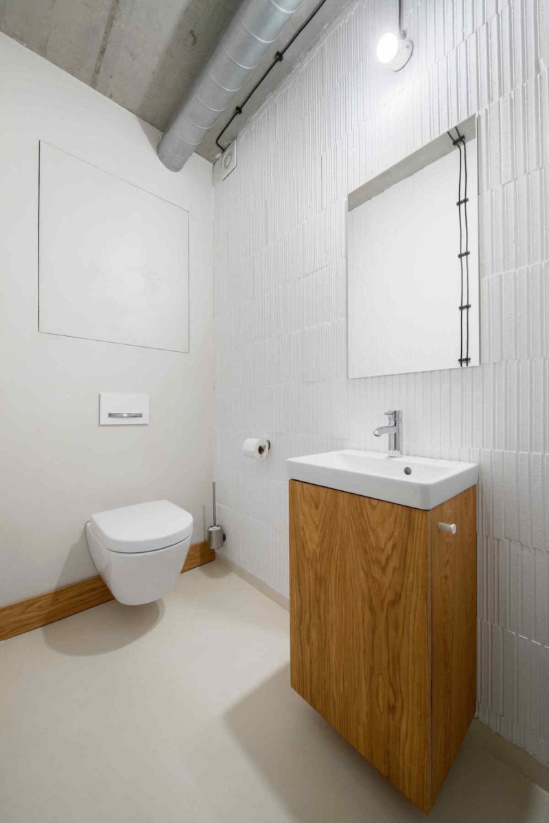 Toaleta v bílé s dřevěným nábytkem