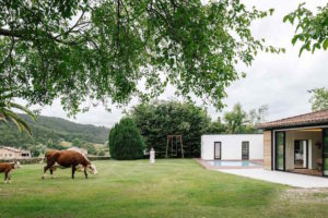 Zrekonstruovaná stáj s bazénem a loukou s krávami