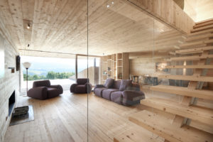 Dřevěný interiér vily s fialovou pohovkou