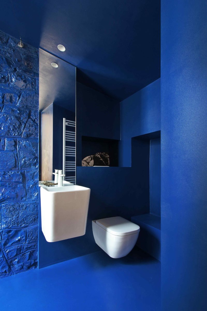 Indigo modrá toaleta s bílou sanitou