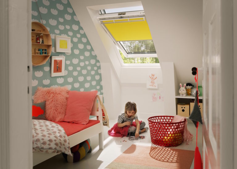 Dětský pokoj s děvčátkem pod střešním oknem