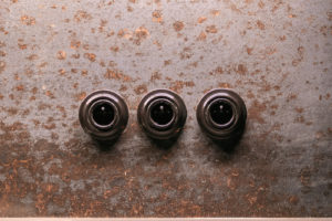 Detaily černých keramických zásuvek a vypínačů