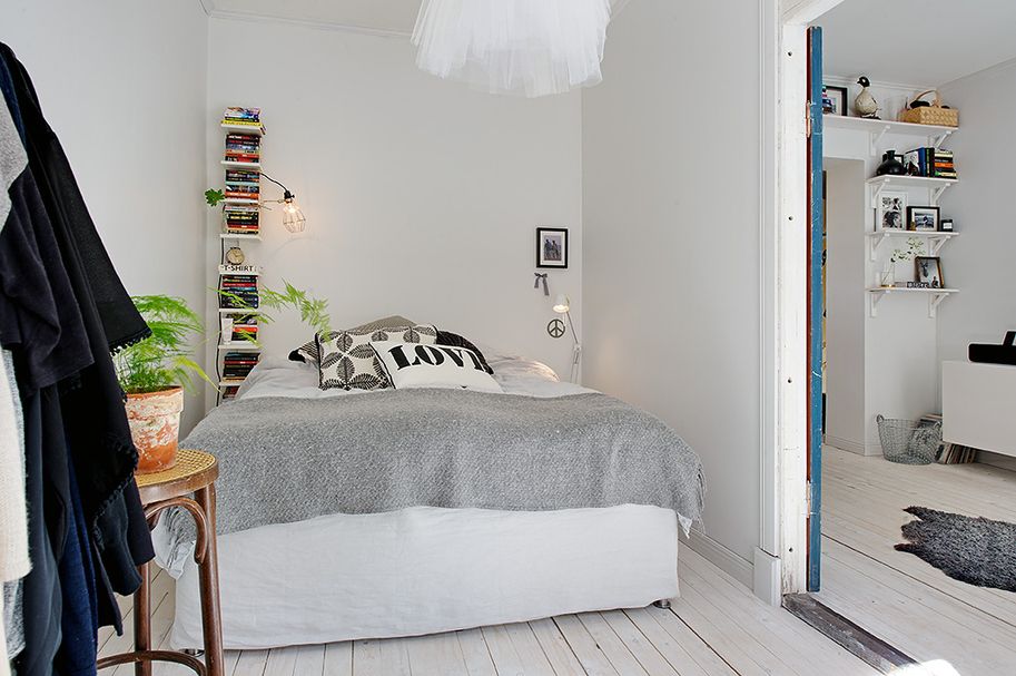 Jednoduchá ložnice s bílým lustrem a mini knihovničkou