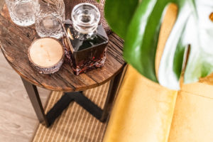 Dřevěný stolek se sklenicemi a láhví na alkohol