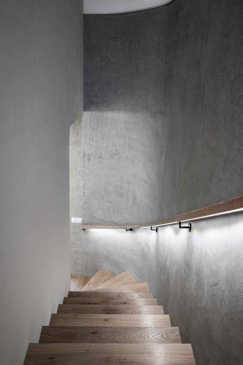 Dřevěné schodiště s bílou a šedou stěnou
