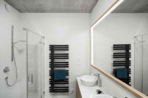 Bílá koupelna s černým designovým radiátorem