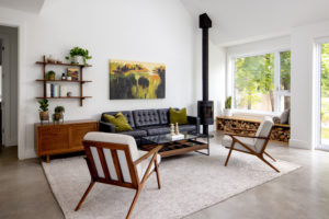 Obývací část s krbem koženým gaučem a retro židlemi