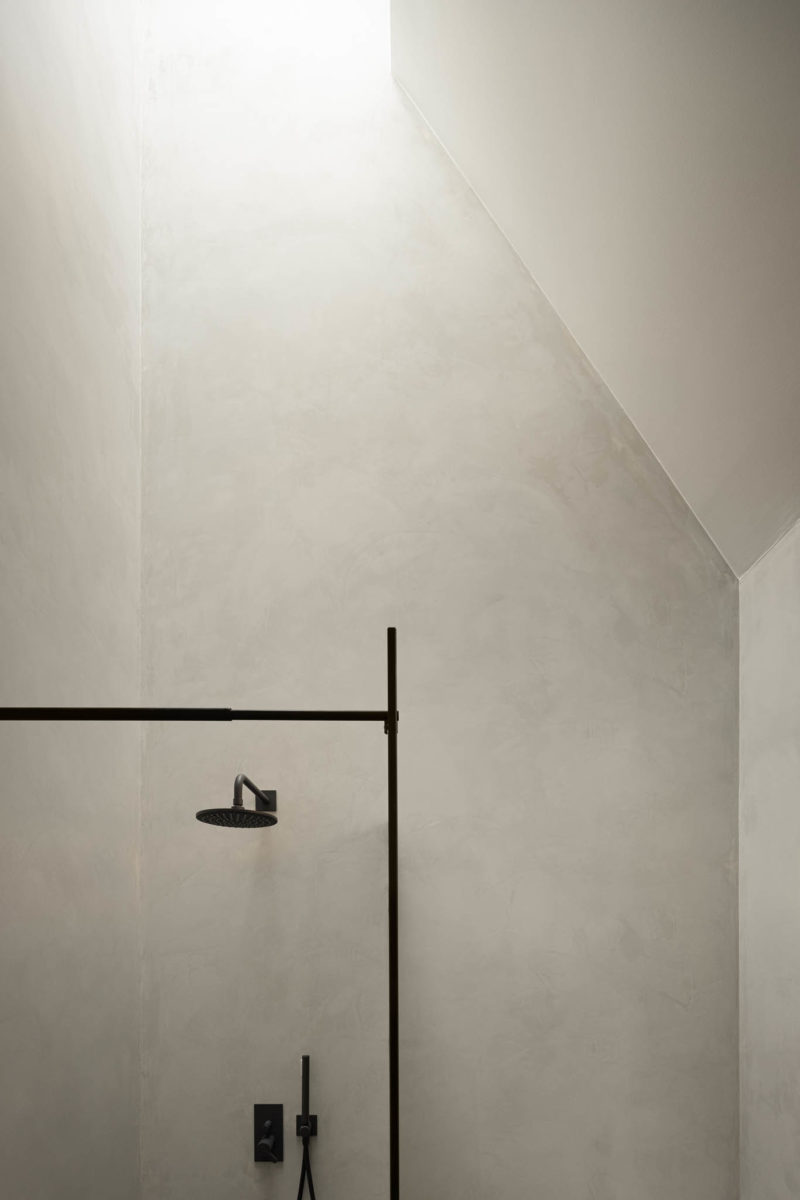 Černý sprchový kout detail na šedé stěne