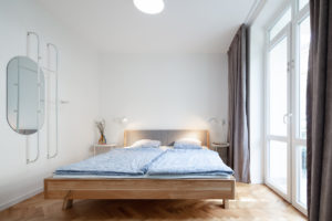Jednoduchá ložnice s parketami a francouzkým oknem