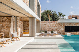 Středomořská vila s kamennou fasádou bazénem a prosklením