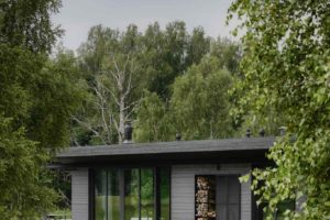Moderní pavilonový dům s prosklením a tmavým obkladem