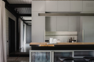 Kuchyň v šedé a černé v moderním stylu s barovými židlemi