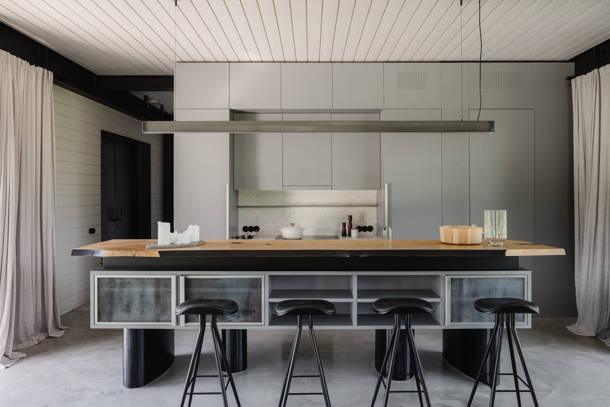 Kuchyň v šedé a černé v moderním stylu s barovými židlemi