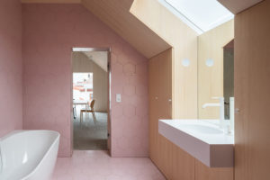 Růžová podkrovní koupelna s dřevěnou zdí
