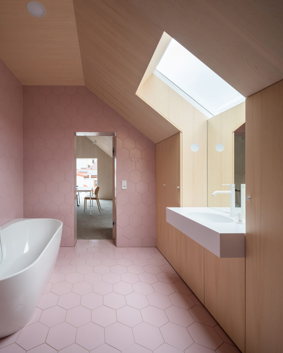 Růžová podkrovní koupelna s dřevěnou zdí