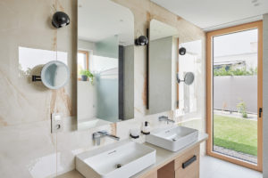 Moderní svetlě mramorová koupelna s oblými zrcadli