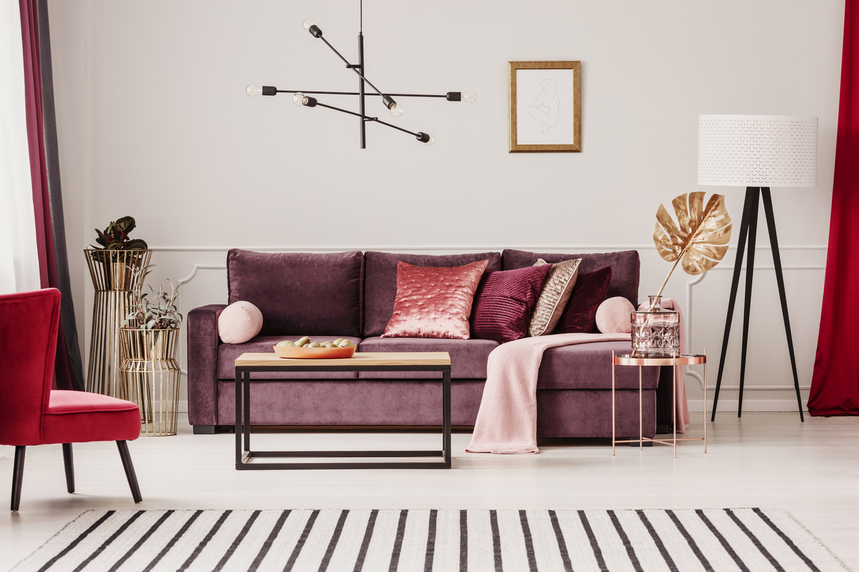 Obývací pokoj se zamatovou pohovkou v rudé a designovým nábytkem