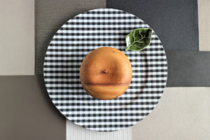 Dřevěné jablko na čtverečkovém talíři
