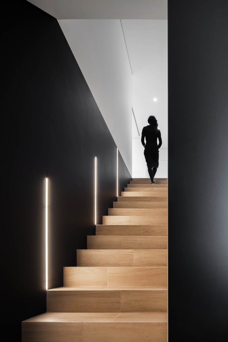 Černohnědé osvětlené schodiště a žena